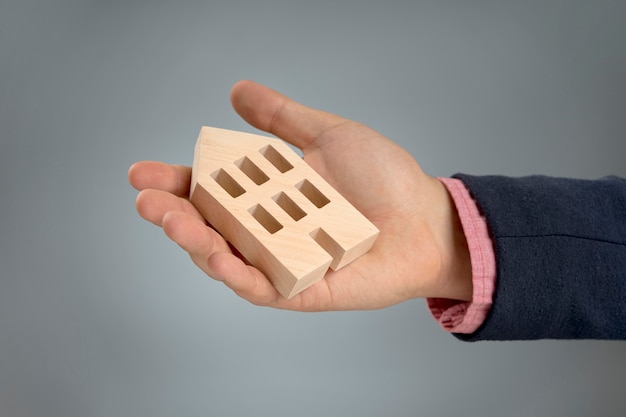 Free photo hand with wooden house